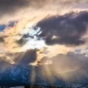 Sunrays shine through clouds from a view on East Campus