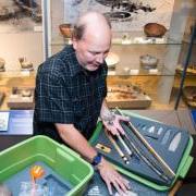 Senior museum educator Jim Hakala, left, and anthropology curator Steve Lekson prepare a fossil kit to be delivered to a Colorado classroom. 